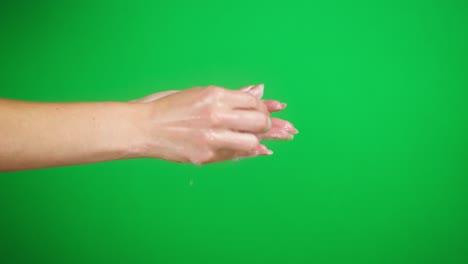 lavar las manos de las mujeres en fondo verde, usando jabón. prevención de virus, protección de seguridad. brazos usando desinfectante de espuma antibacteriana de cerca