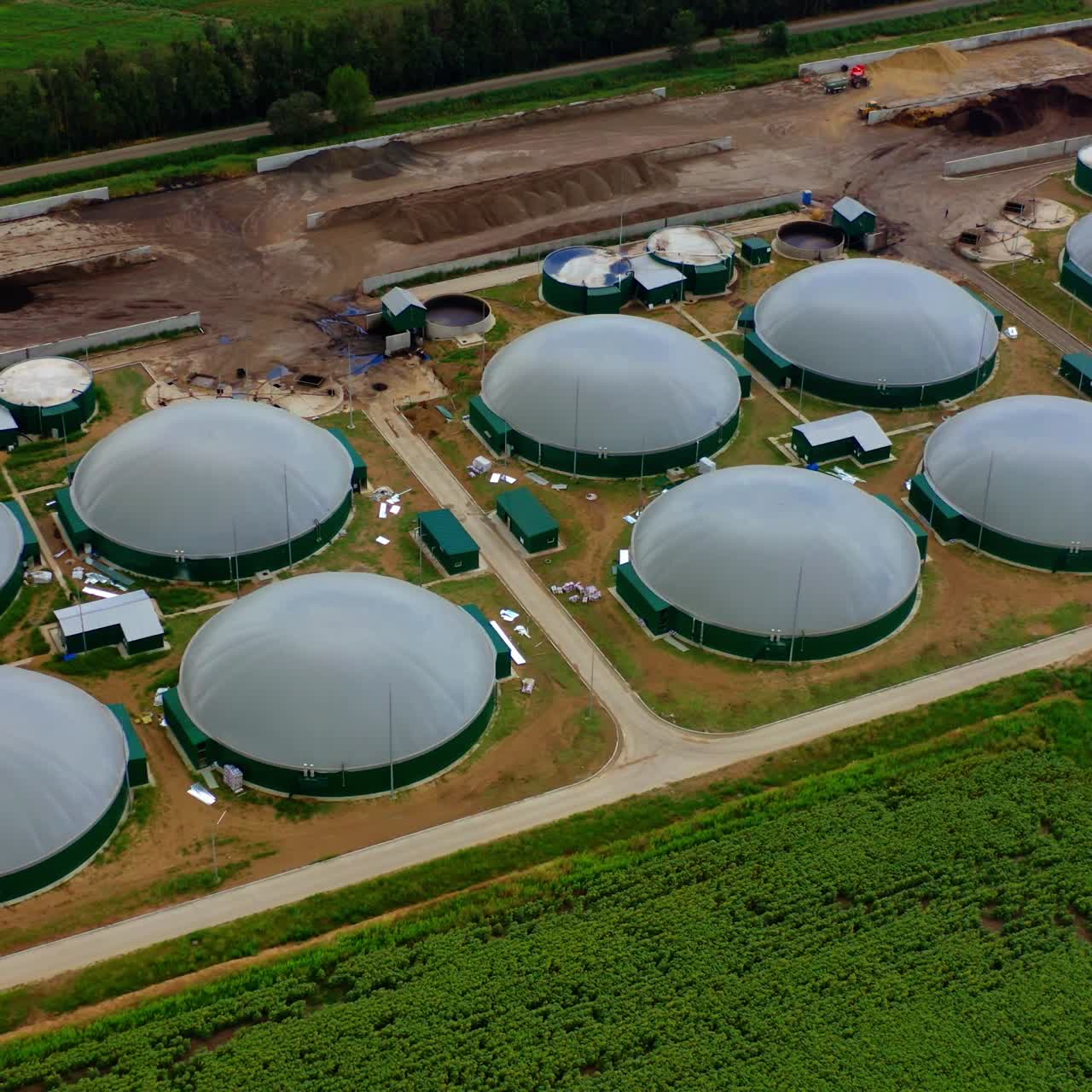Exterior of biogas complex. Biogas is produced by fermenting biomass. Storage tanks for organic gas on the field. View from the air.
