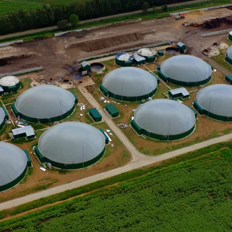 exterior of biogas complex. biogas is produced by fermenting biomass. storage tanks for organic gas on the field. view from the air.