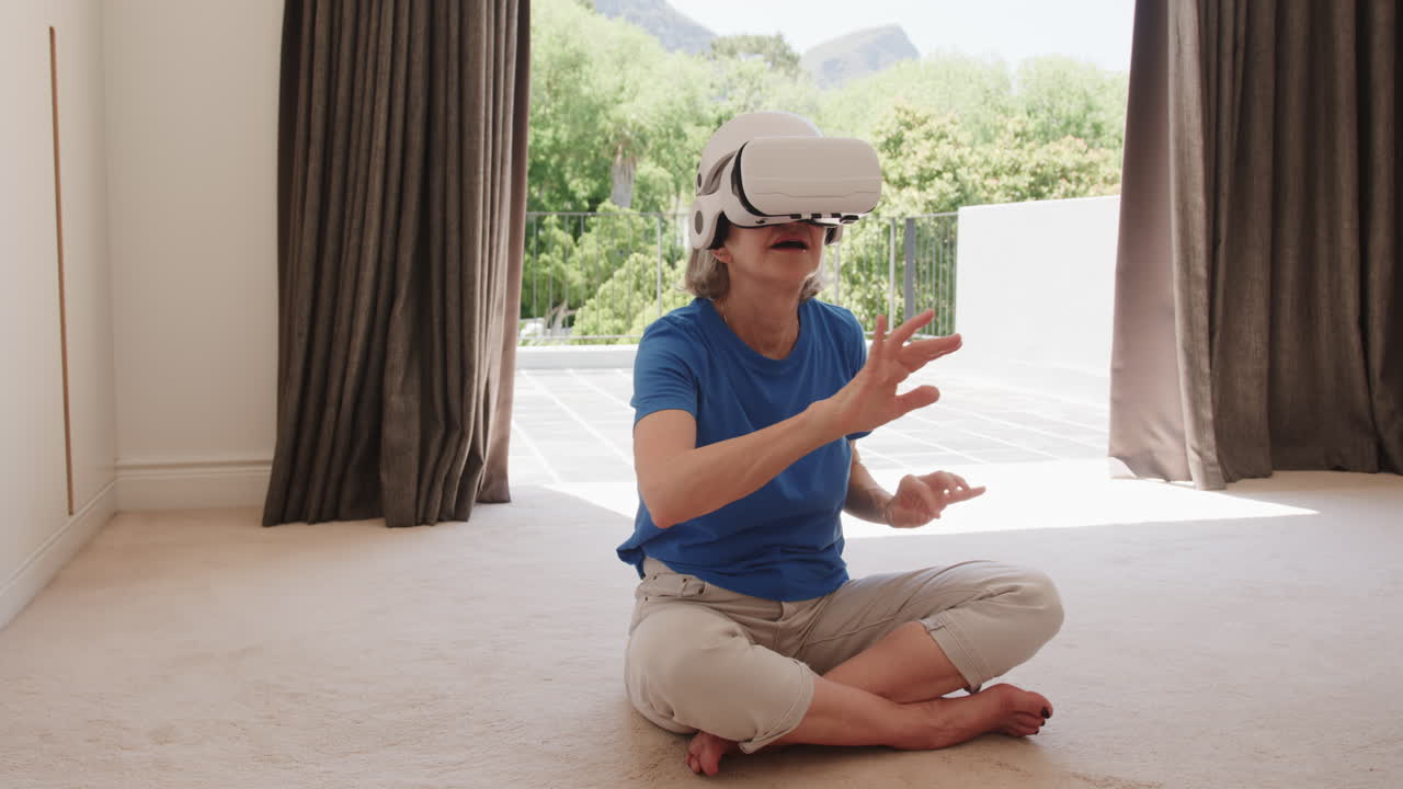 Senior woman using VR headset, exploring virtual world while sitting on floor, at home