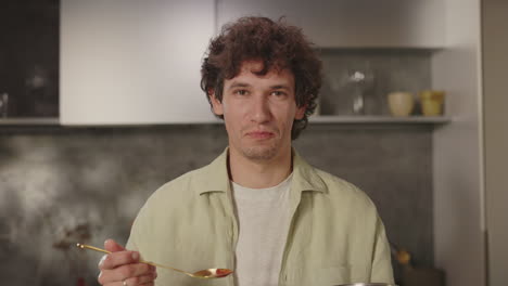man tasting food while cooking in the kitchen