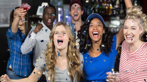 animation of confetti falling over happy diverse group of friends drinking in bar