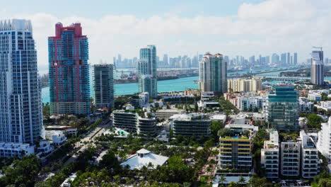 a smooth drone flyout reveals the vibrant skyline of south beach, miami, with turquoise waters and downtown skyscrapers in the distance.