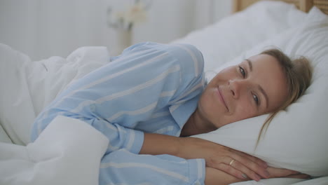 people waking up - young woman opens her eyes on a sunny morning