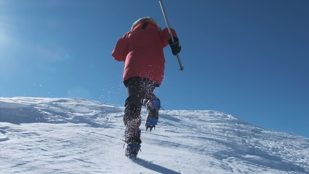 el hombre corre a lo largo de una empinada pendiente nevada desde atrás en cámara lenta