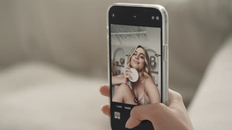 woman taking a selfie with a cup in hand