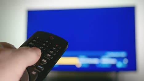 male hand operating a remote control for a smart tv