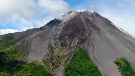 majestic mount merapi volcano cone in clouds on java, indonesia, aerial view