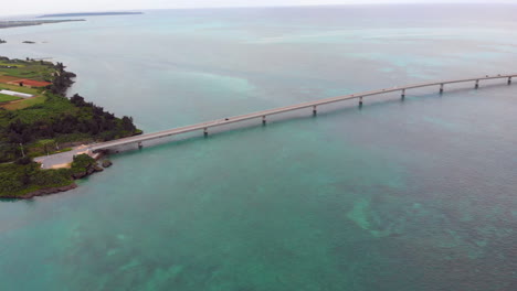 Wide-shot-of-a-car-passing-the-Irabu-ohashi-bridge,-Miyako-jima,-Japan