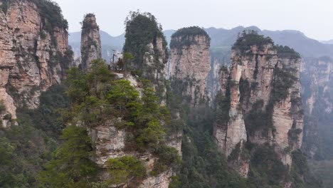 a sweeping drone shot of zhangjiajie's towering rock pillars, showcasing the lush forests and dramatic formations that define this iconic chinese landscape