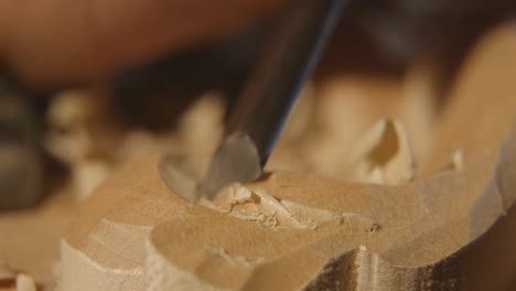a man is wood carving a piece of classical furniture. shot in macro lens.