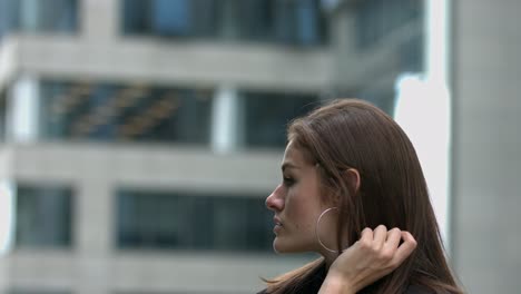 a young women looks around her surroundings in a modern campus setting