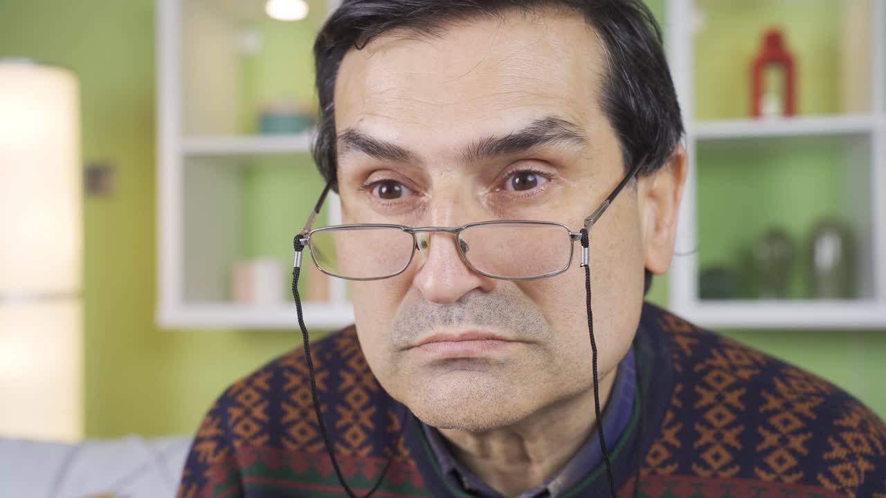 un primer plano de un anciano enojado y malhumorado que se estremece en casa.