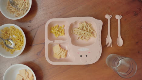 overhead view of a meal being prepared placing in a kid's portion plate