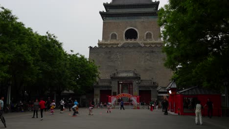 chinese people skating and enjoying the day at bell tower esplanade in beijing, china