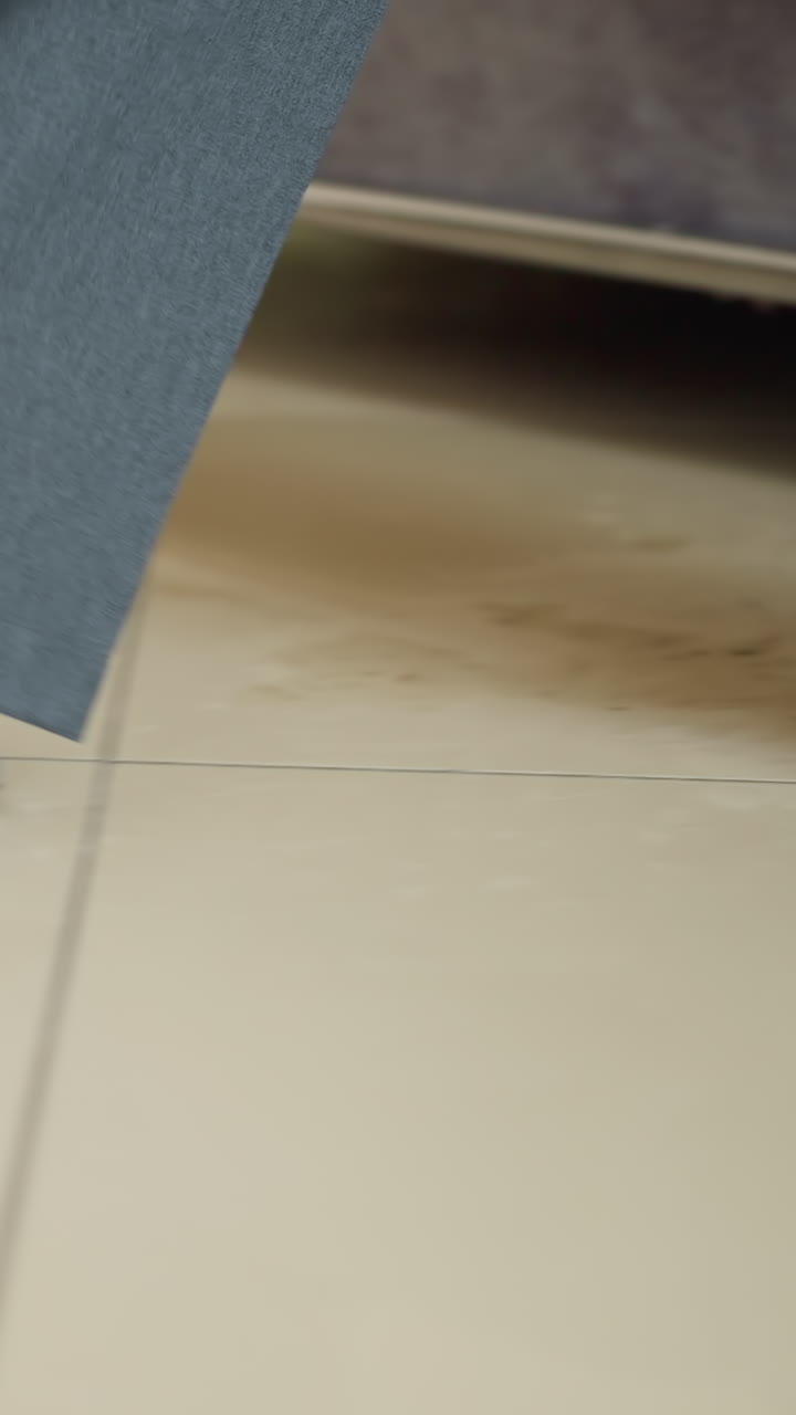 Motion-blurred close-up of business professional walking in gray formal trousers and light socks across corporate office floor. Dynamic movement shows confident stride over beige