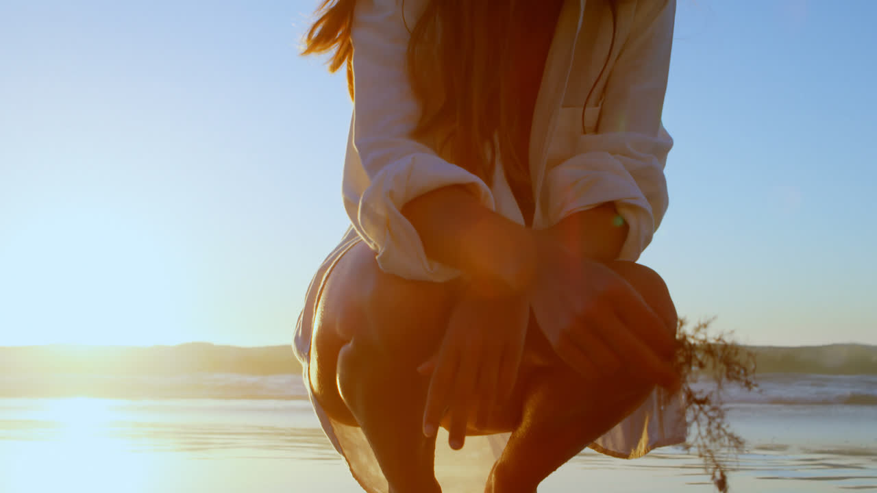 해변에서 말린 식물을 들고 있는 여자 4k