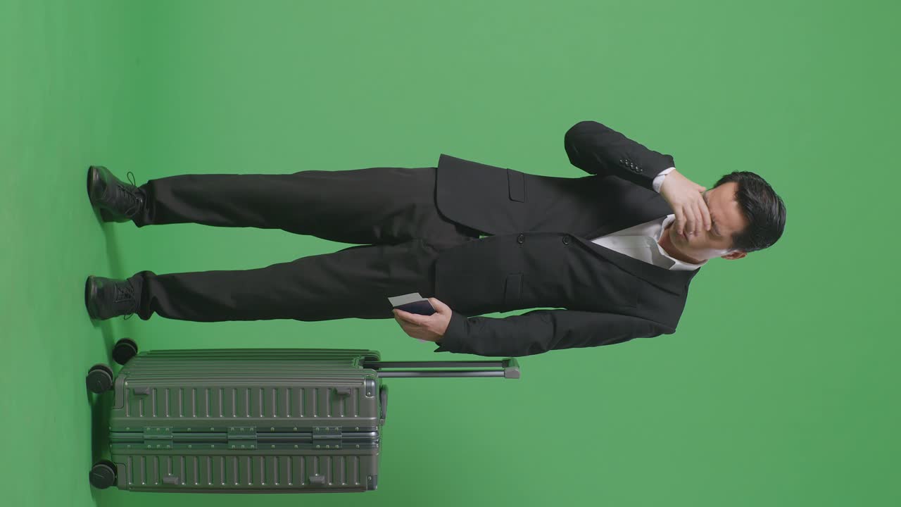 아시아 사업가의 몸이 가득 차 있습니다. 수하물과 여권을 가진 여행자는 녹색 스크린 배경 스튜디오에 서있는 동안 두통을 겪고 있습니다.