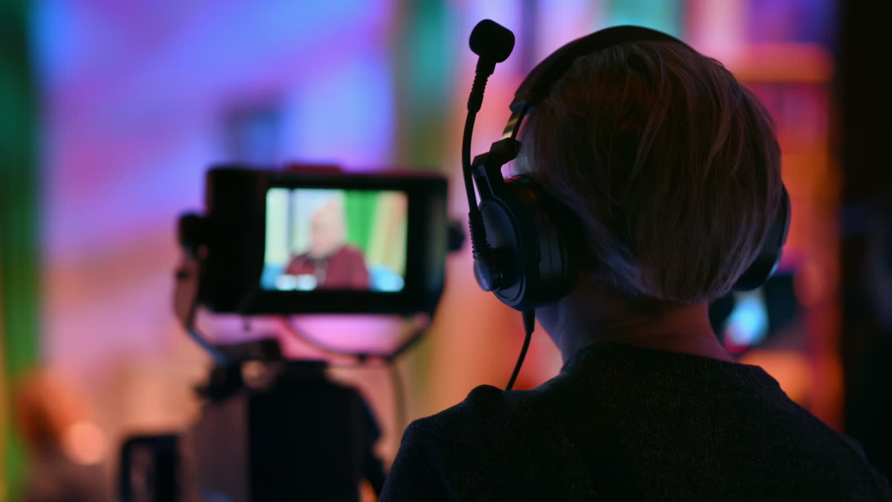Cameraman filming a television talk show on a professional camera. Video production backstage in a dark studio