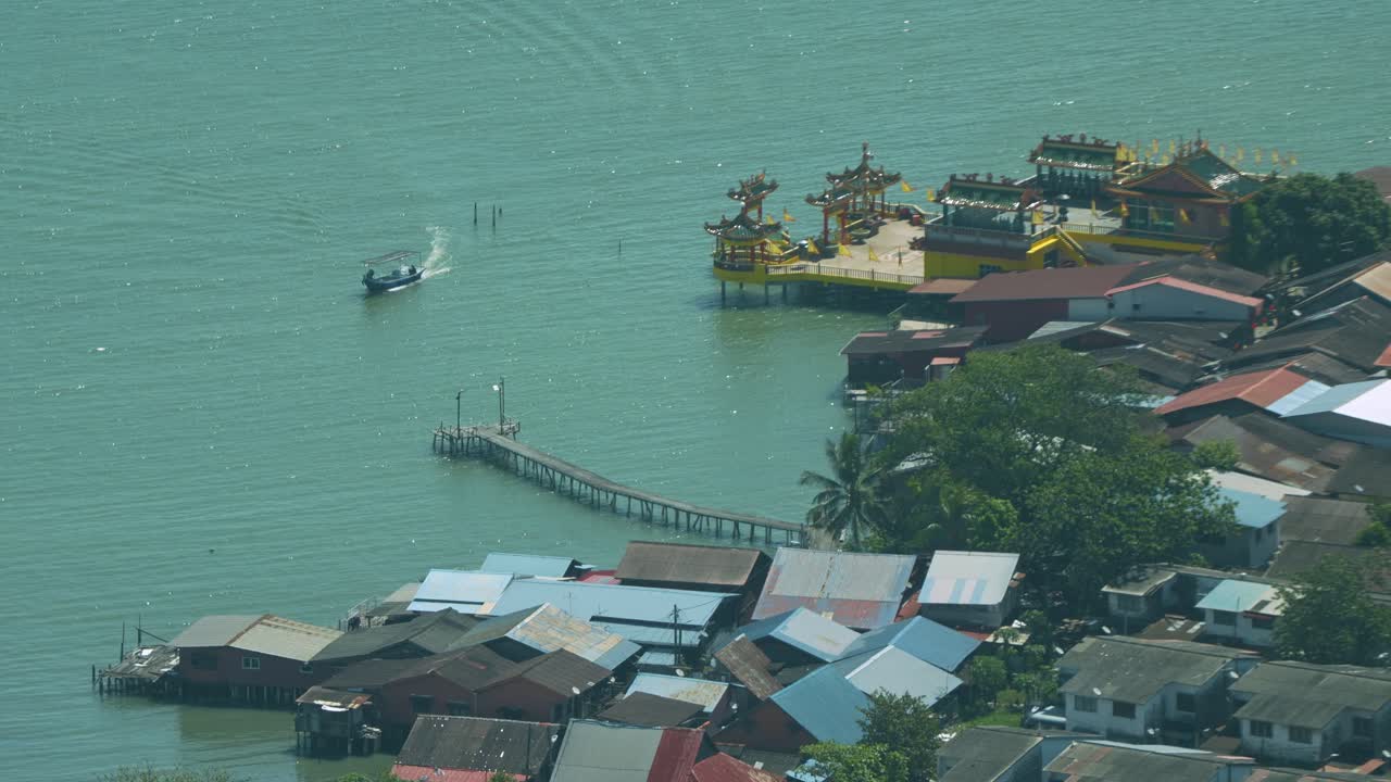 Penang's vibrant coastal cityscape, showcasing Kuan Yin Temple and traditional stilt houses.