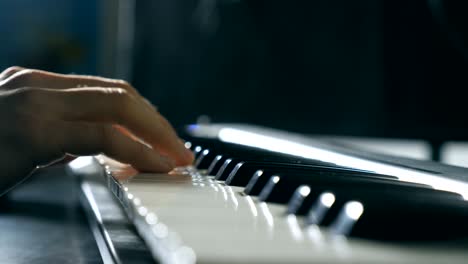 close up fingers of pianist at the piano keys. mens arms plays solo of music or new melody. hands of male musician playing at synthesizer. slow motion isolated shot