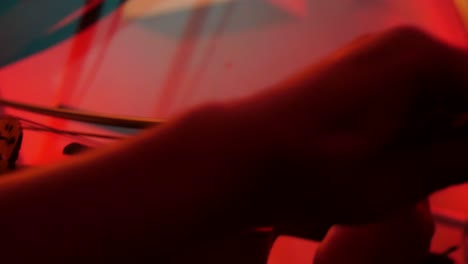 Man-Plays-Violin-Under-Red-Light-in-Studio