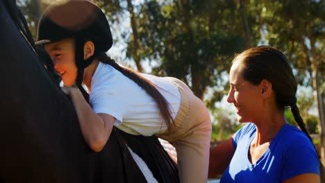 madre ayudando a su hija durante la equitación 4k