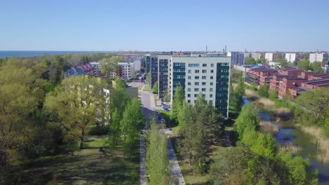 vista aérea de los edificios de apartamentos del distrito residencial llenos de gente en un día soleado de verano, casas renovadas y aisladas, paredes coloridas de la fachada, parque verde, tiro de drones de gran angular avanzando