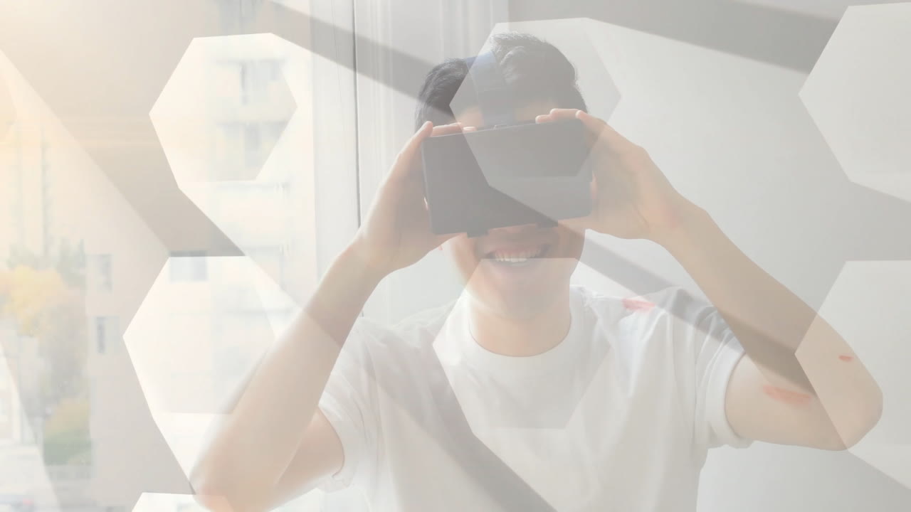 Man using VR headset exploring digital technology indoors, showing animated hexagon graphics