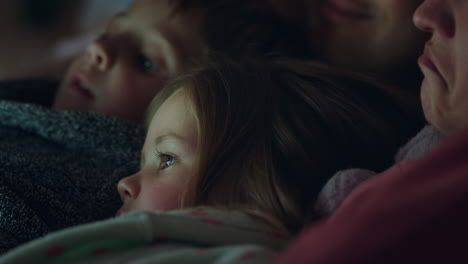 happy family using tablet computer mother and father enjoying watching entertainment with kids on touchscreen technology relaxing before bedtime