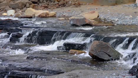 Cascada-De-Un-Amplio-Arroyo-Que-Fluye-Sobre-Rocas-Creando-Una-Pequeña-Cascada-En-La-Playa-En-La-Península-De-Kenai-De-Alaska