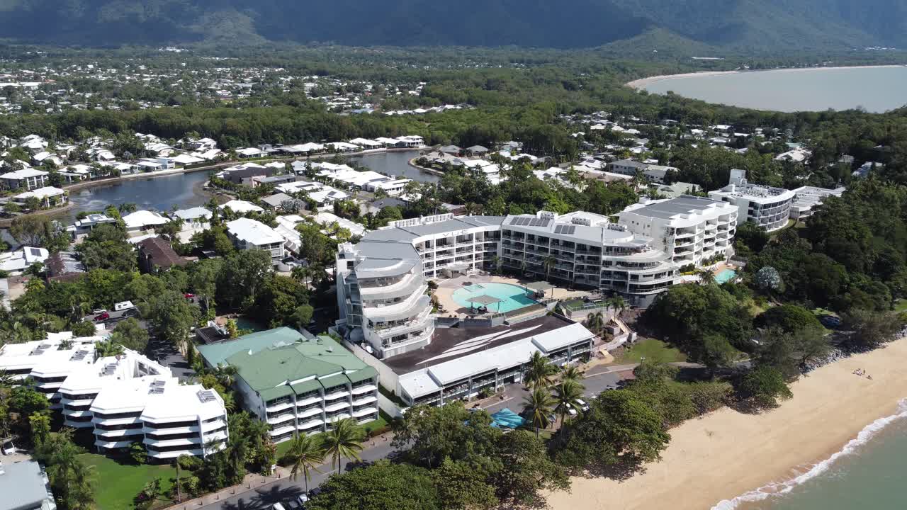 4K drone shot of a luxury hotel next to a sandy beach on Trinity Beach in North Queensland, Australia