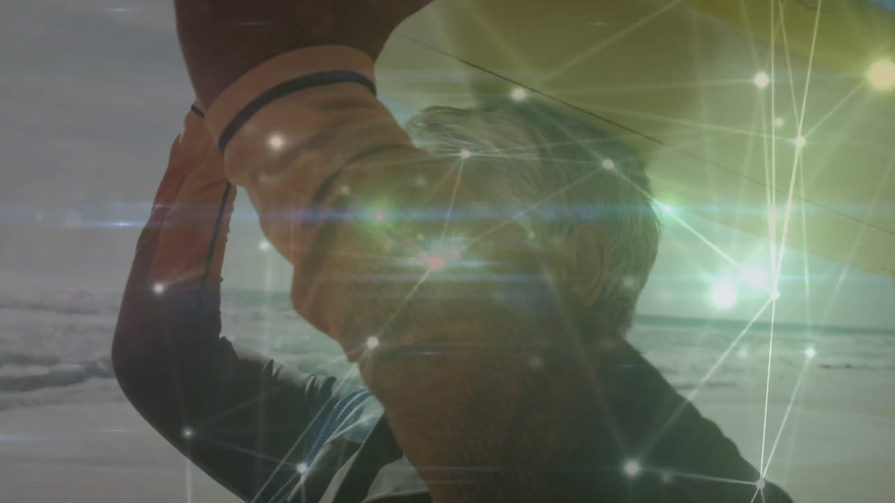 Man holding yellow surfboard overhead at beach gazing horizon, glowing technology network overlay