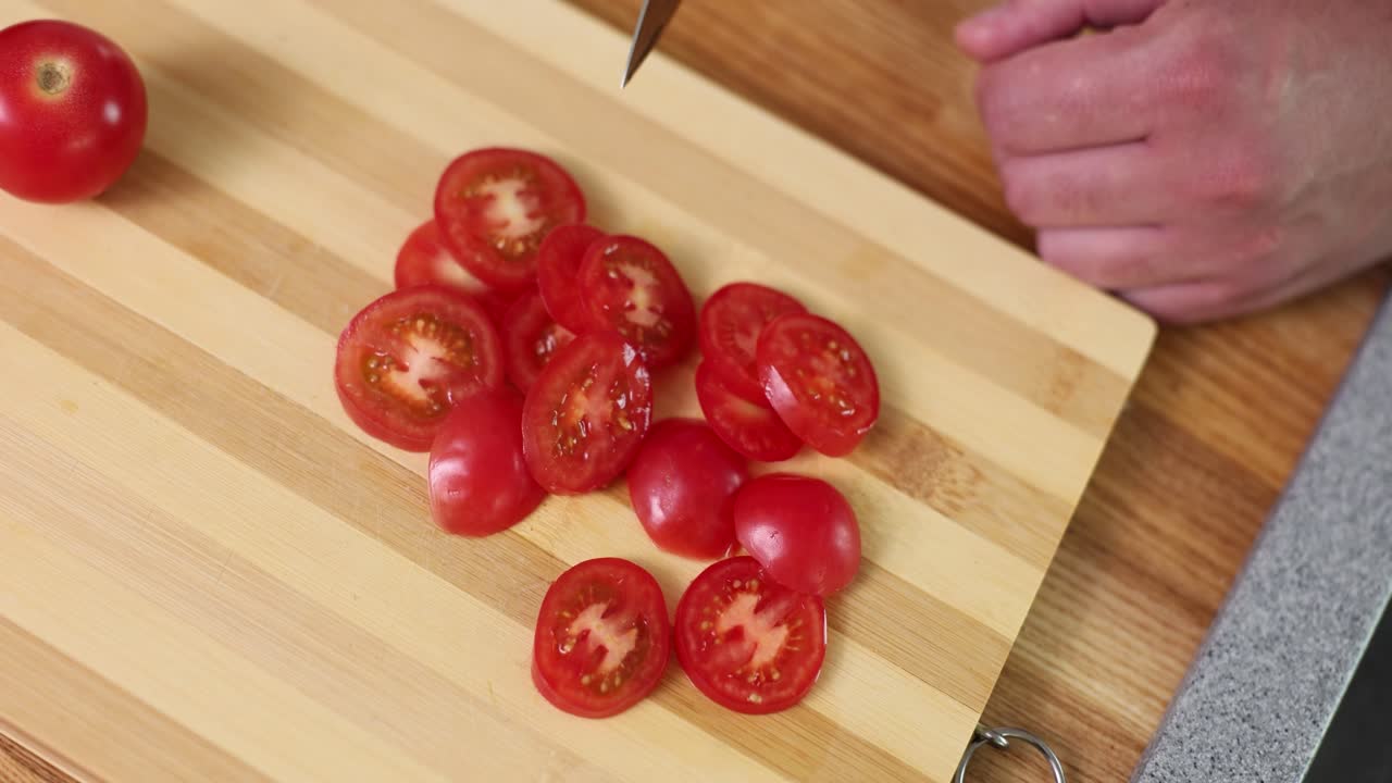 Slicing cherry tomatoes on a cutting board