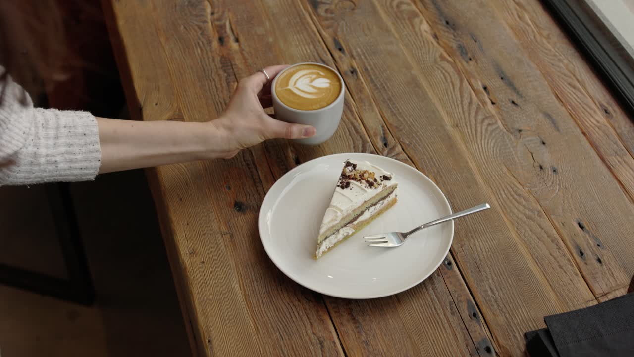 mujer disfrutando de café y pastel en una cafetería