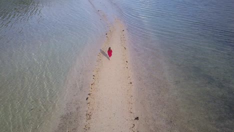 Luftaufnahme-Einer-Jungen-Brünetten-Frau-Im-Roten-Kleid,-Die-Abseits-Der-Kamera-Auf-Einer-Sandbank-In-Asien-Läuft