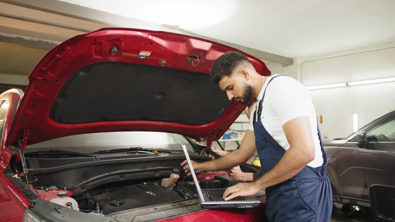 Homens sérios e concentrados, mecânicos técnicos de automóveis, reparando um problema no motor do carro durante a verificação do sistema.