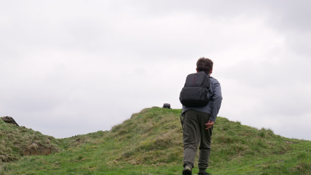 습지 에서 야외 에서 어린 소년 이 그의 rc 자동차, 트럭, 4 x 4 와 함께 놀고 있다