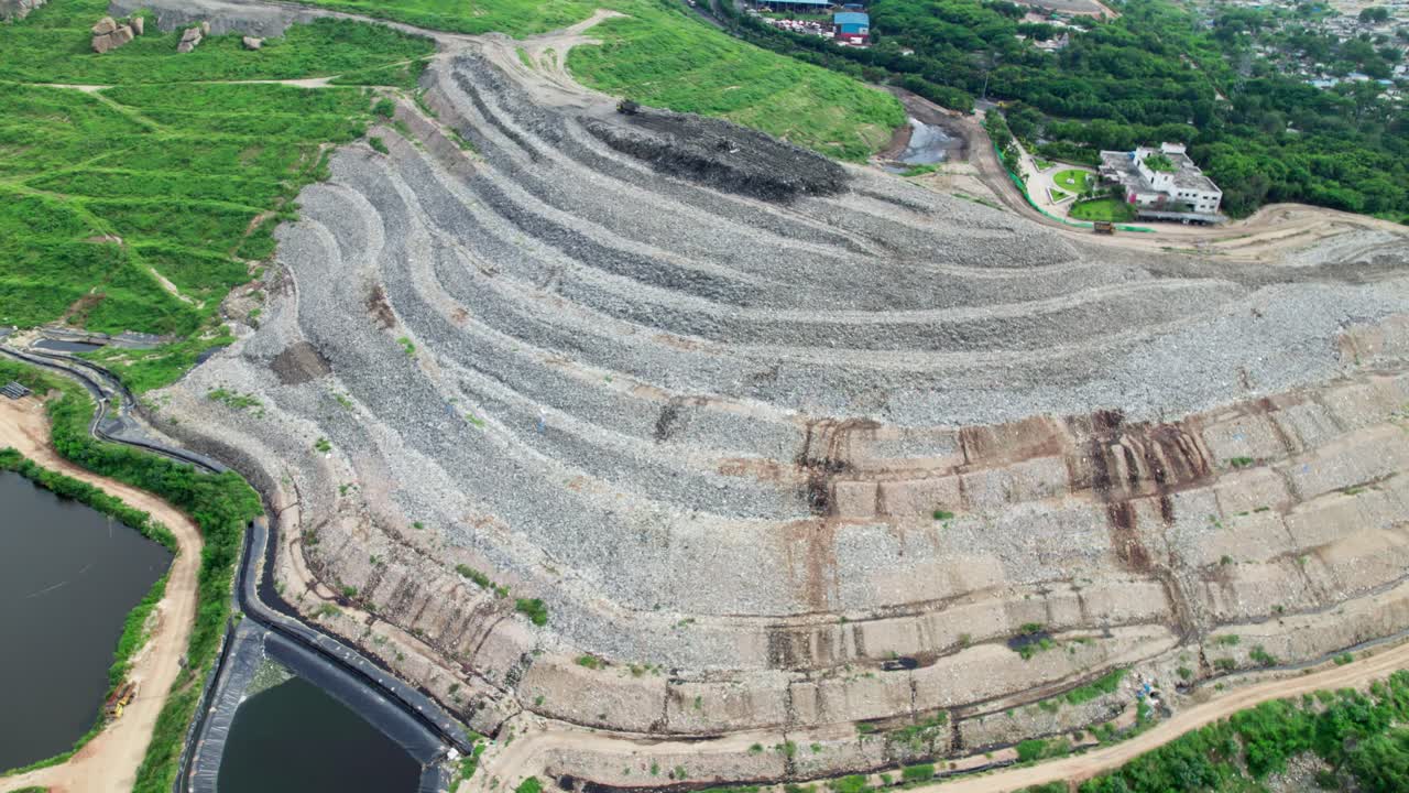 Large scale of urban dumping yard with greenery and water ponds at balaji nagar, hyderabad, telangana, india. day time, push in shot, tilt down shot, drone shot, 4k