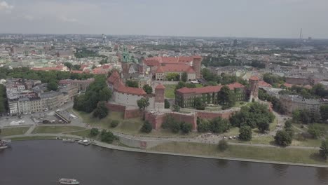 Polen,-Krakau-Drohnenaufnahme-Von-Der-Vorderseite-Des-Schlosses-Wawel-Mit-Wisla-Im-Vordergrund-Und-Gebäuden-Im-Hintergrund