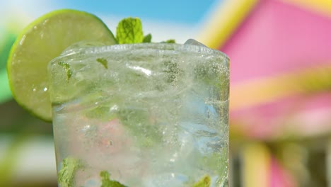 white rum is added to fresh mojito, shallow depth of field of tropical pink home background