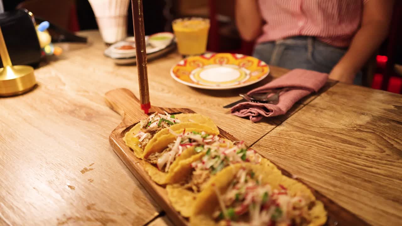 A joyful dining experience in a Mexican restaurant with tacos and a sparkler, highlighting vibrant ambiance and festive mood
