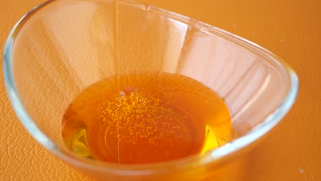 honey pouring into a glass bowl