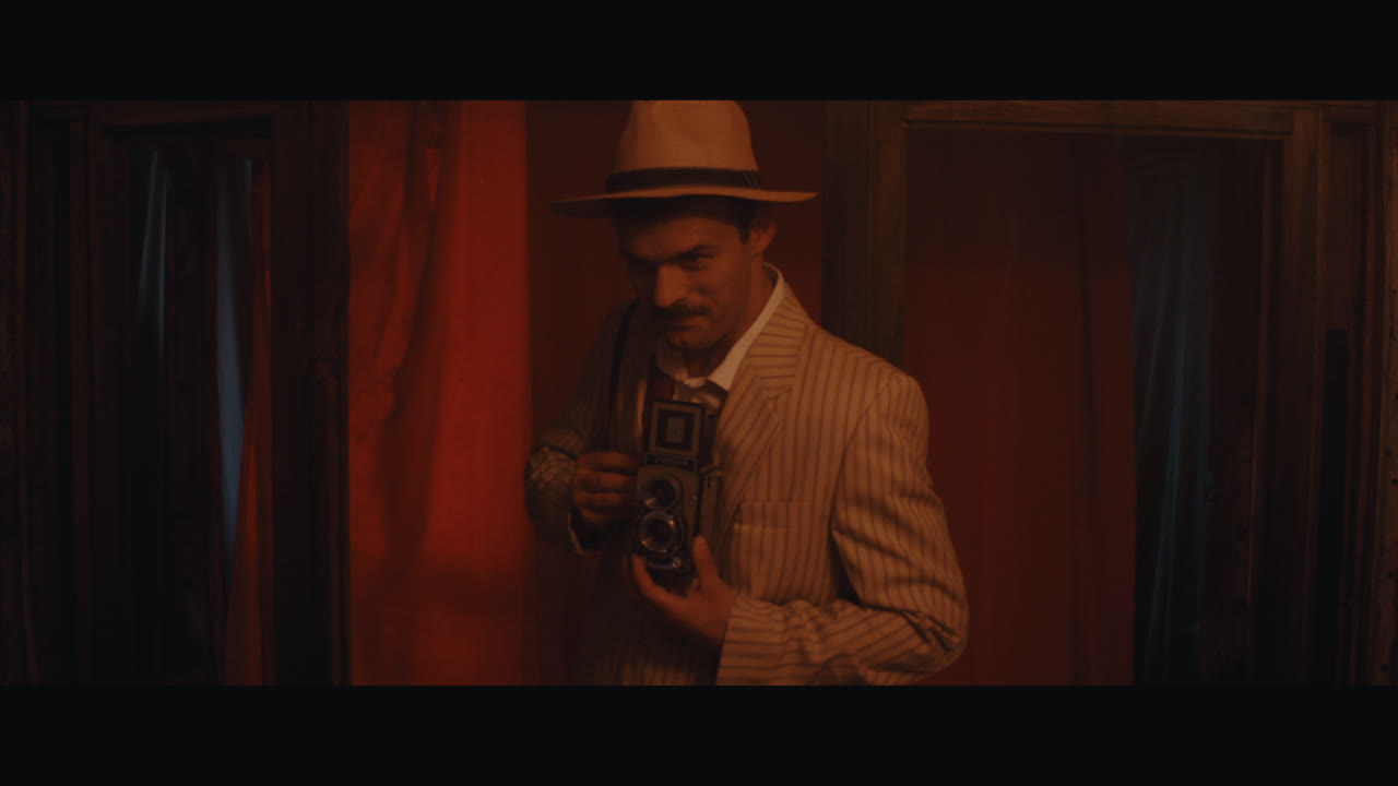 A man in hat goes inside the the circus cart and takes a photo