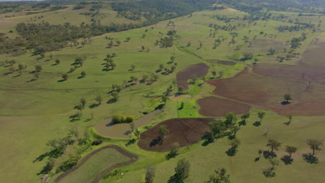 Australian-Countryside-Drone-Pan-Up-To-Wind-Turbines-On-Horizon,-4K