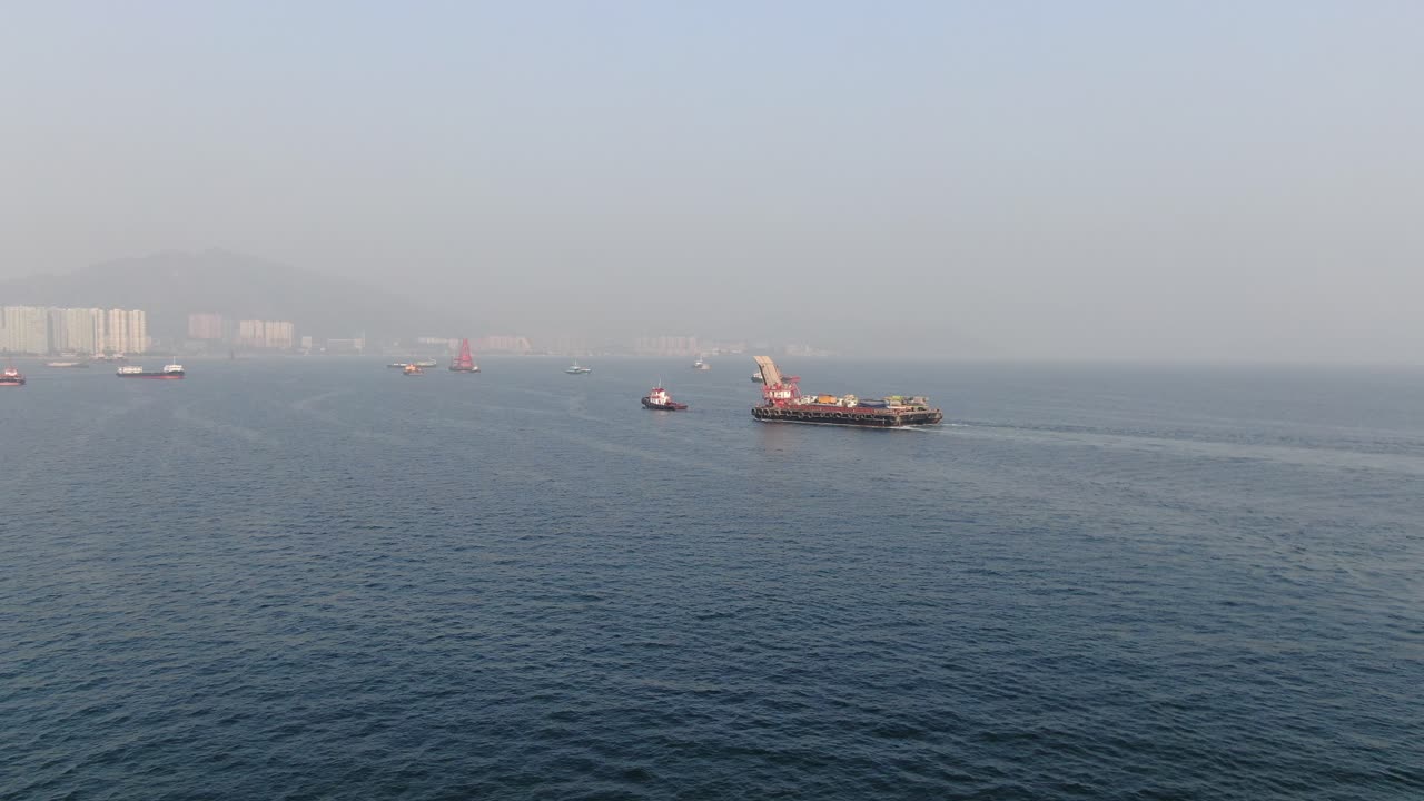 홍콩 만의 예인선으로 항구로 끌려간 콘크리트 믹서 트럭을 실은 바지선, 공중 전망