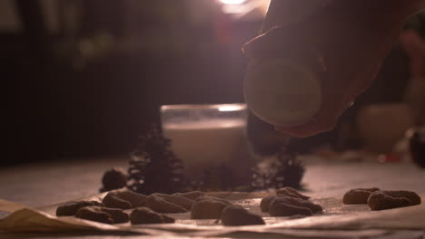 close up, woman's hands grinding flour powdered sugar onto crescent raw cookies
