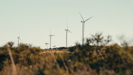 The-wind-turbines-in-motion,-harnessing-the-power-of-the-wind-to-provide-clean-energy-in-the-mountains