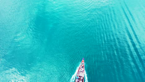 barco de cola larga navegando en vibrantes aguas turquesas, rastreando la superficie del mar reflejando la luz del sol en tailandia, espacio de copia