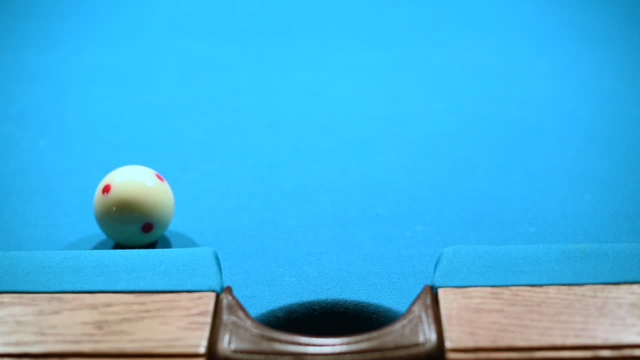 Close up shot of making three ball in the side pocket in american pool billiard